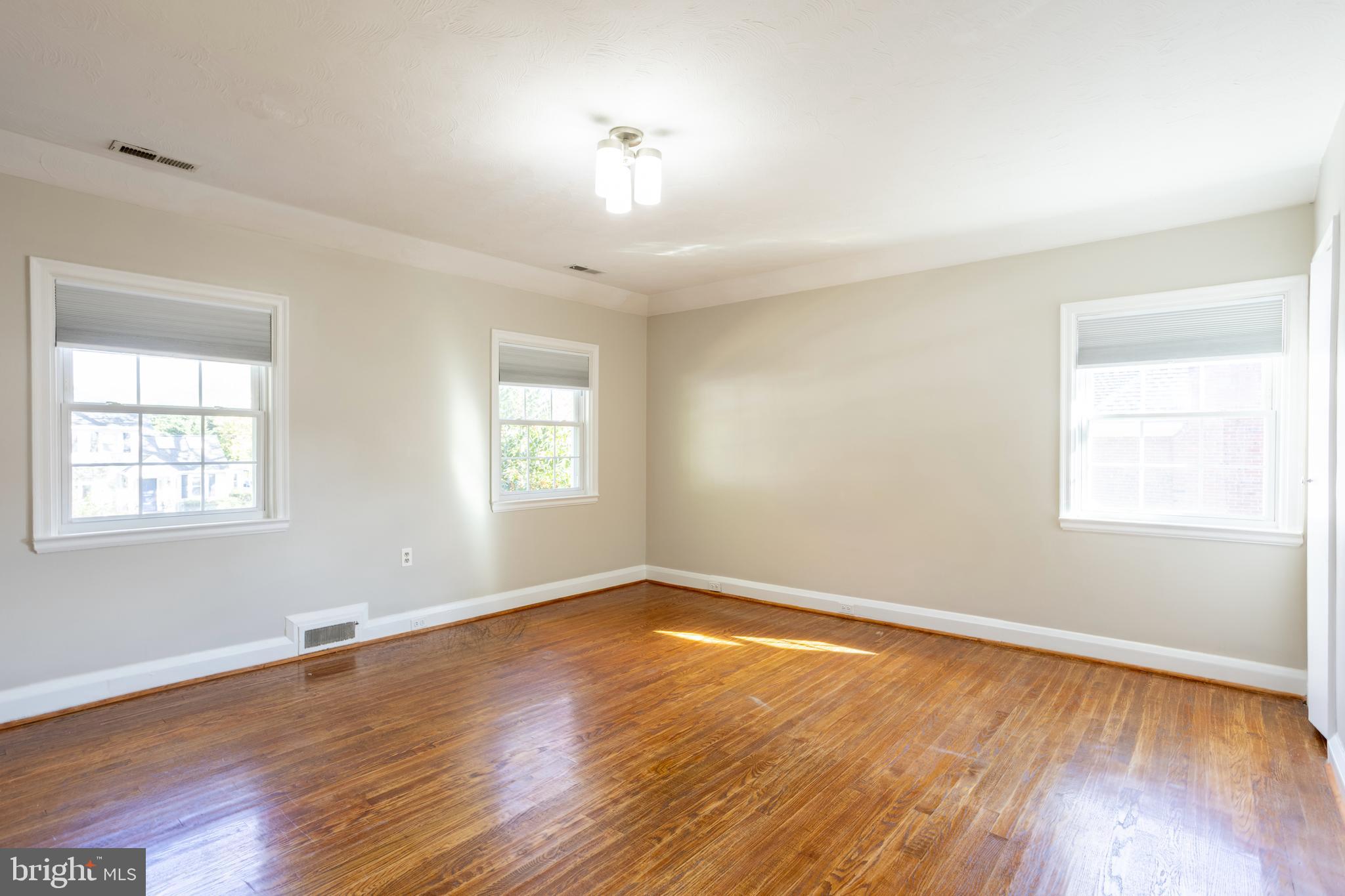 3306 Labyrinth Road Baltimore, MD 21215 - Photo 48 of 66 an empty room with wooden floor and windows