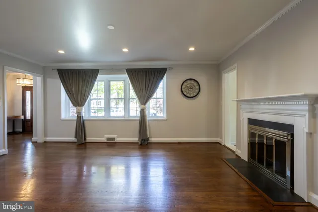 an empty room with wooden floor and fireplace