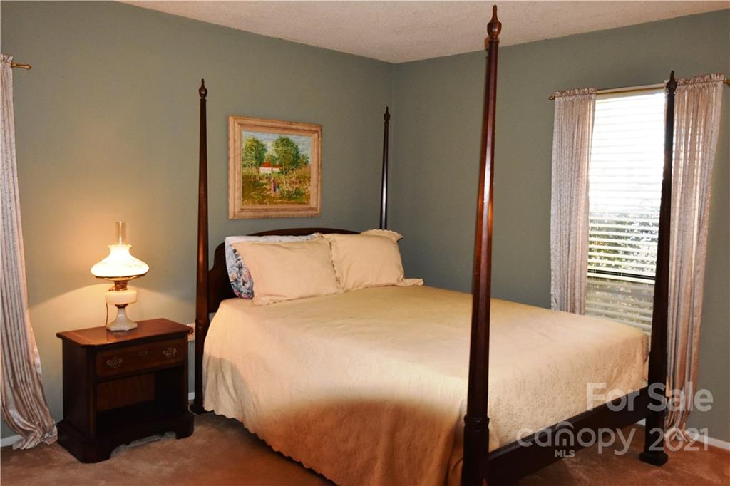 4906 Sardis Road, Unit E Charlotte, NC 28270 - Photo 17 of 24 a bedroom with a bed and a lamp