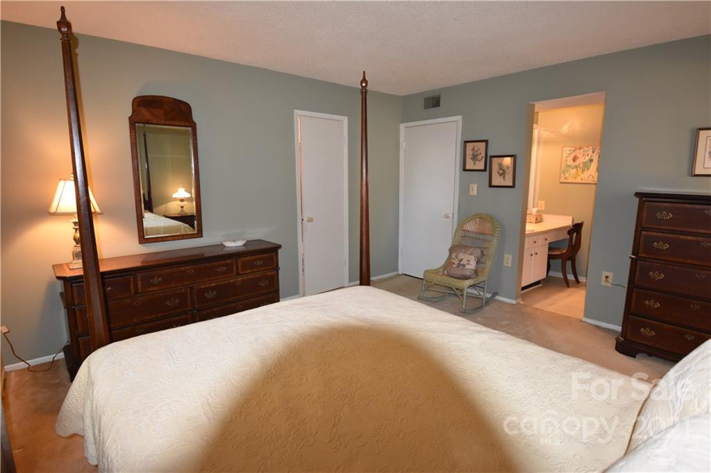 4906 Sardis Road, Unit E Charlotte, NC 28270 - Photo 19 of 24 a bedroom with a bed and a mirror on dresser