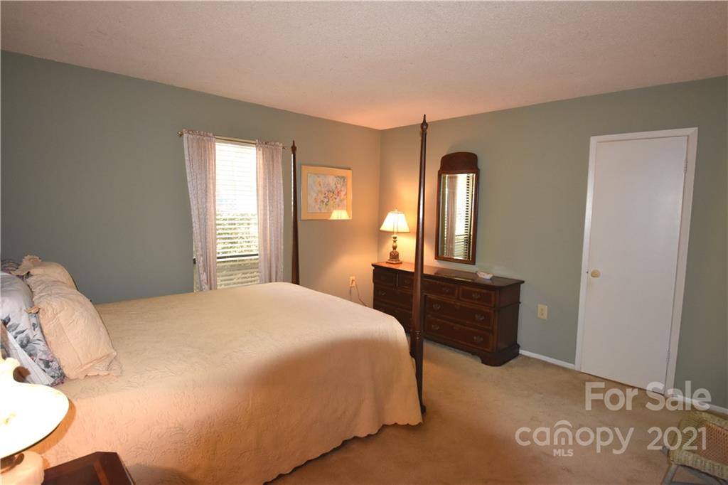 4906 Sardis Road, Unit E Charlotte, NC 28270 - Photo 20 of 24 a bedroom with a bed and a dresser with mirror
