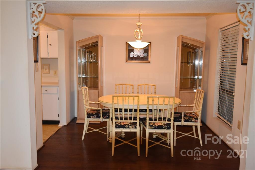 4906 Sardis Road, Unit E Charlotte, NC 28270 - Photo 5 of 24 a view of a dining room with furniture wooden floor and chandelier