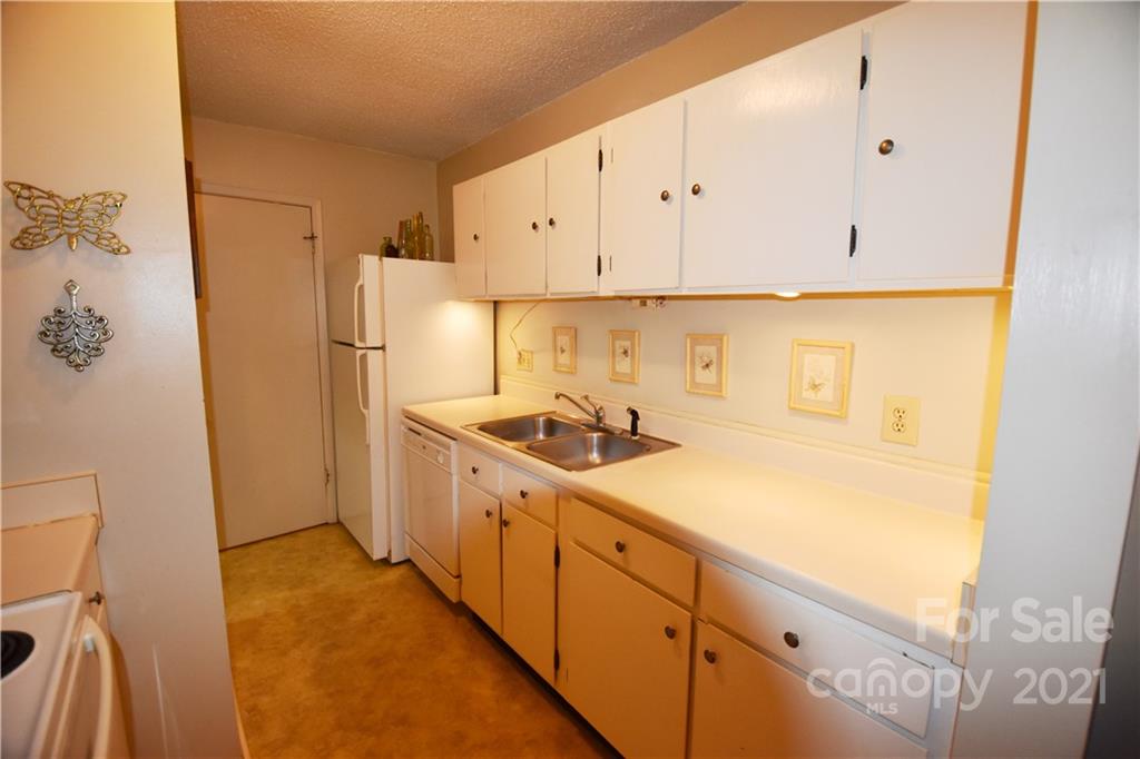 4906 Sardis Road, Unit E Charlotte, NC 28270 - Photo 7 of 24 a kitchen with granite countertop white cabinets and white appliances