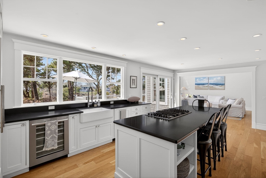 70 Judges Way Chatham, MA 02633 - Photo 8 of 41 a kitchen with a stove a sink a kitchen island with chairs and wooden floor