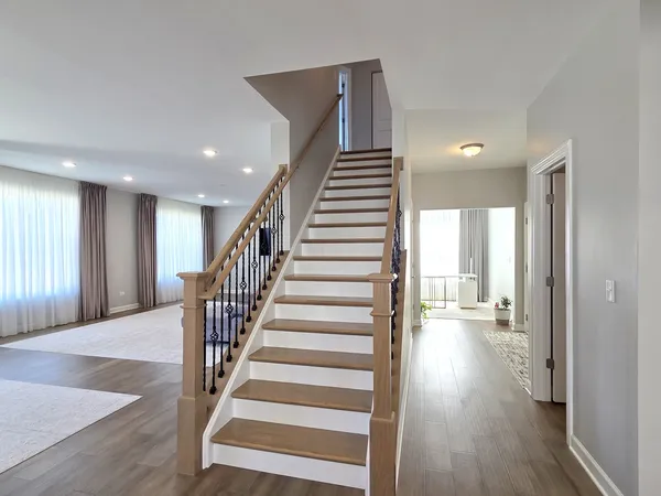a view of a hallway with wooden floor and entryway