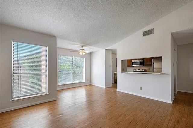 a view of a room with wooden floor and a window