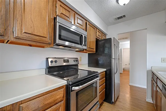 a kitchen with stainless steel appliances granite countertop a stove microwave and refrigerator