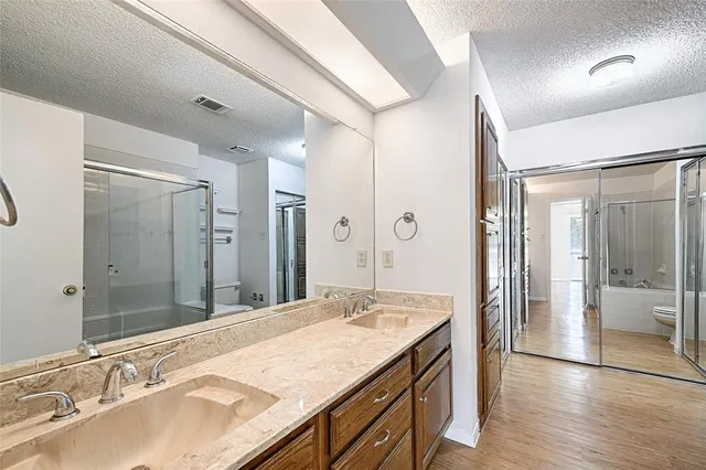 a bathroom with a granite countertop sink mirror and shower