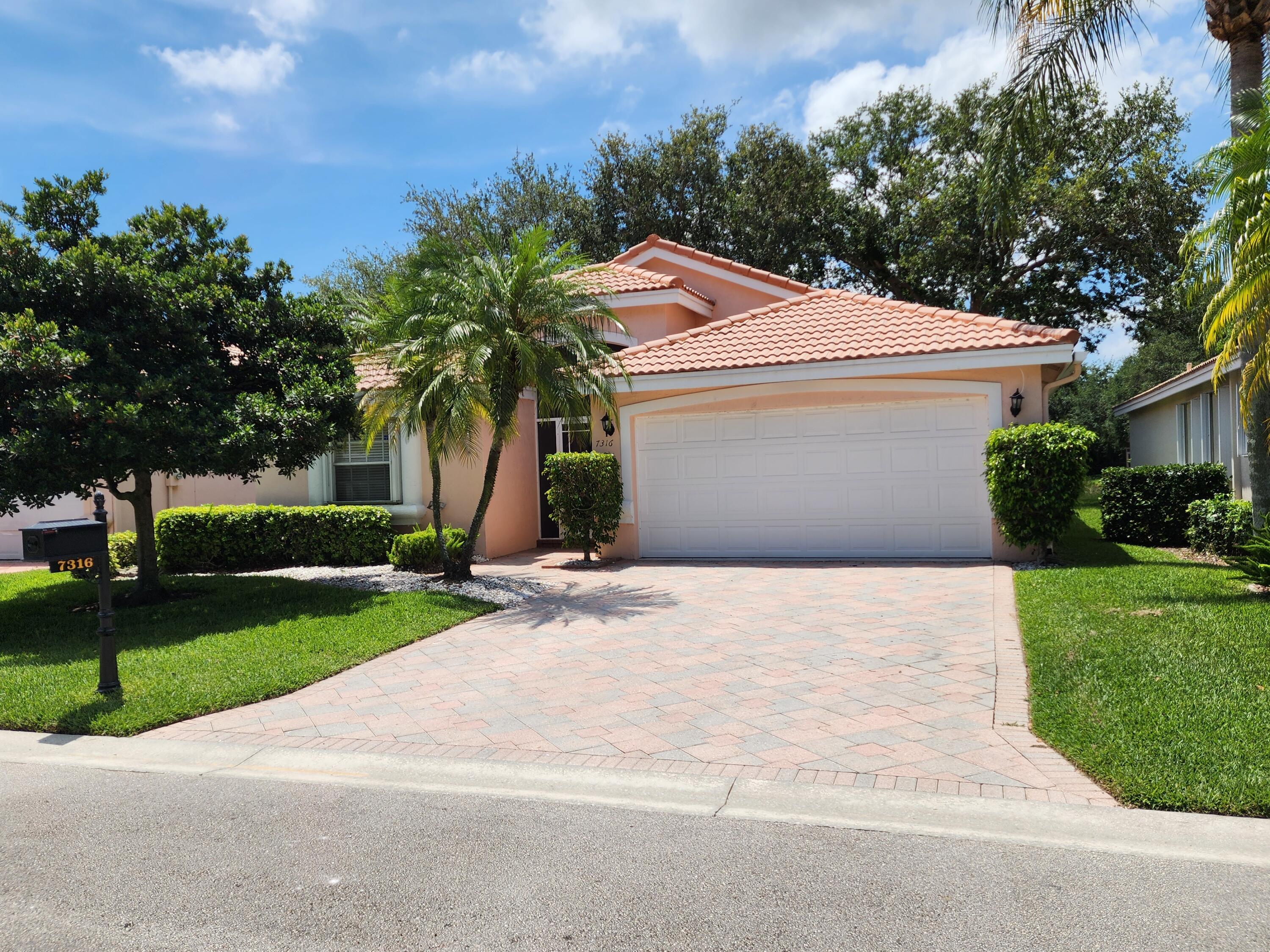 7316 Modena Drive Boynton Beach, FL 33437 - Photo 1 of 24 a palm tree sitting in front of a house with a yard