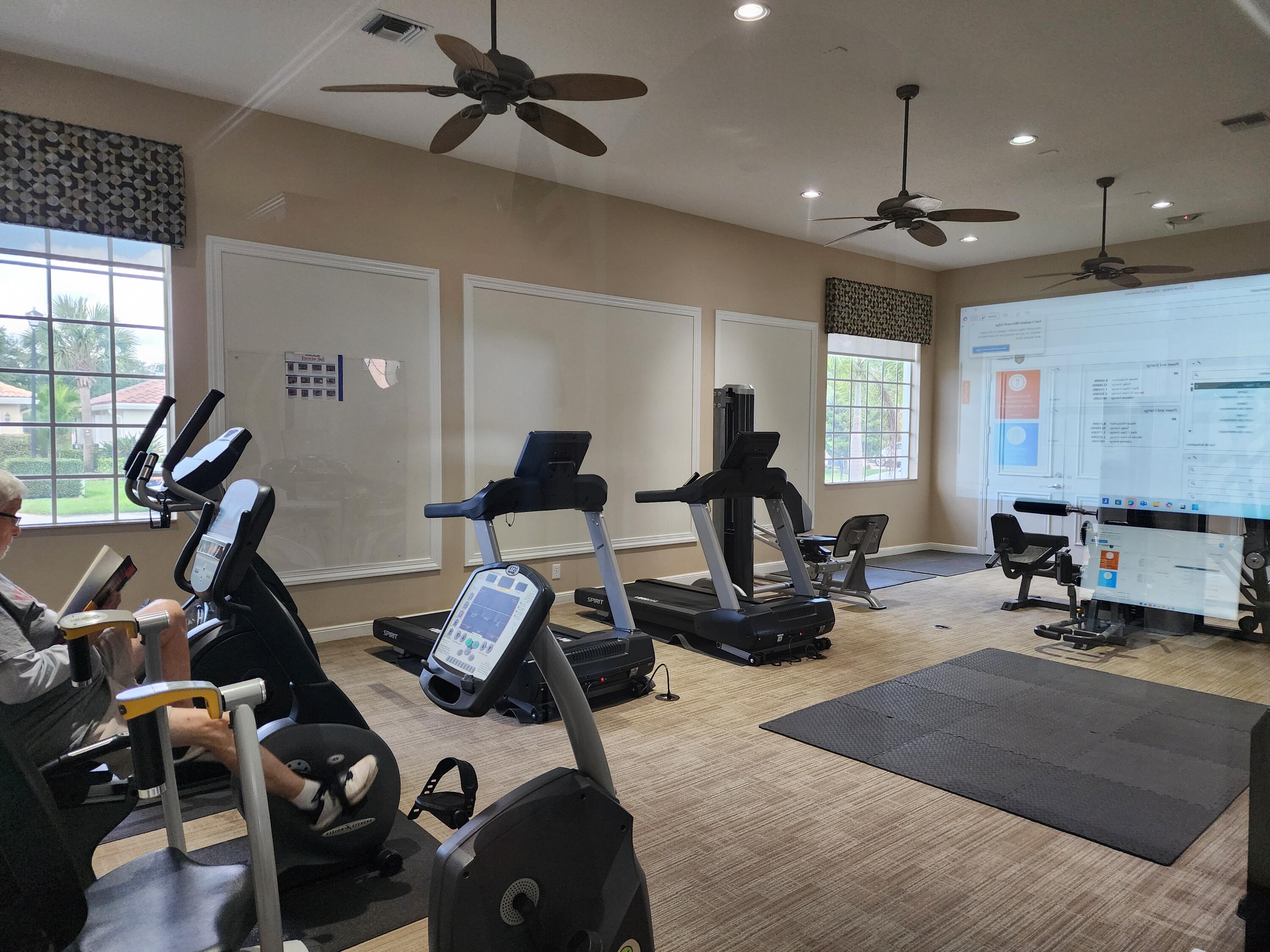 7316 Modena Drive Boynton Beach, FL 33437 - Photo 20 of 24 a living room with furniture gym equipment and a chandelier