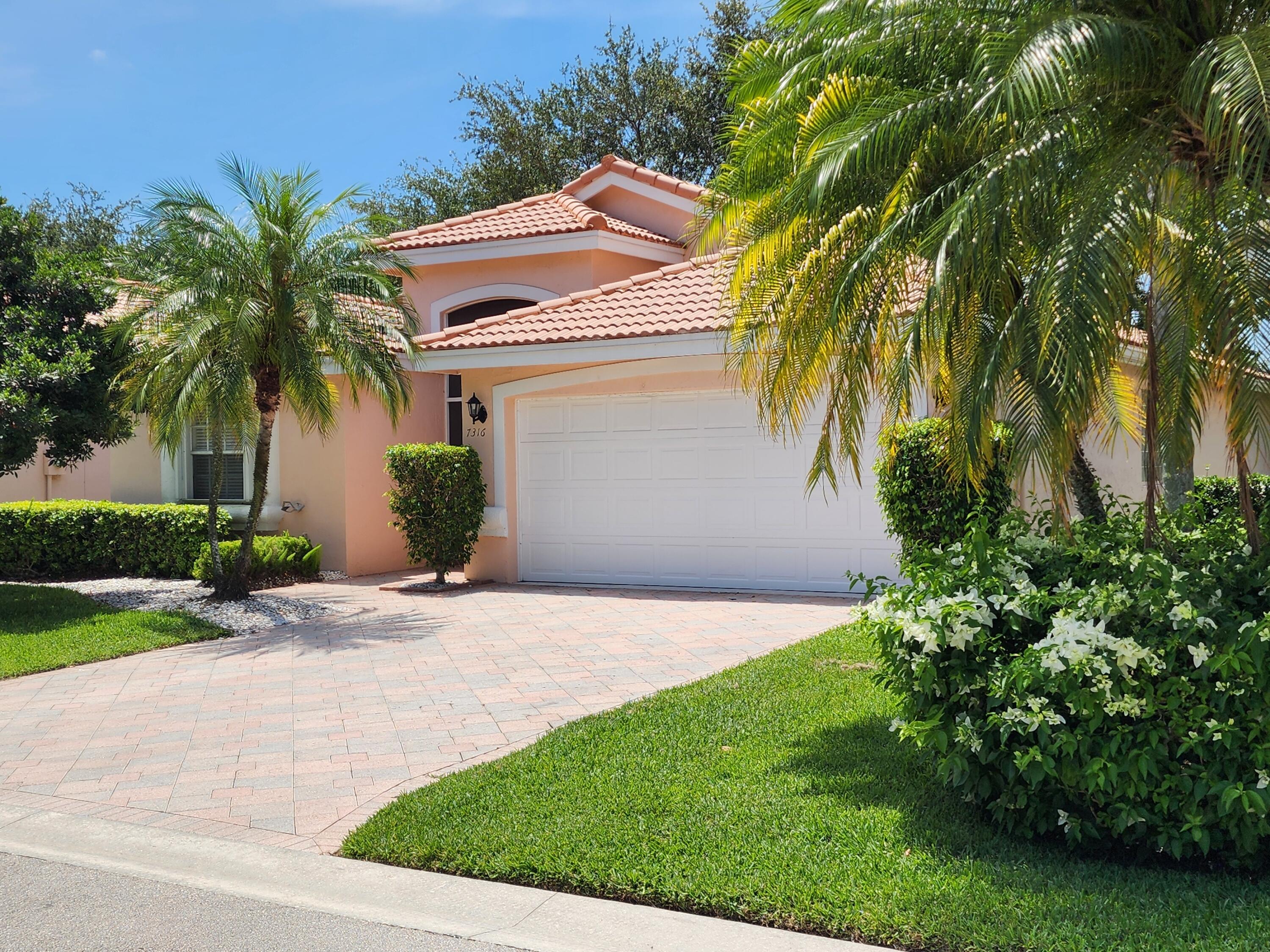 7316 Modena Drive Boynton Beach, FL 33437 - Photo 2 of 24 a front view of a house with garden