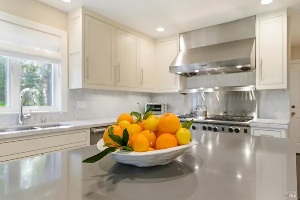 a kitchen with stainless steel appliances a sink a stove and a window