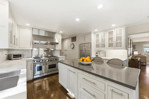 a kitchen with stainless steel appliances a sink a stove and cabinets