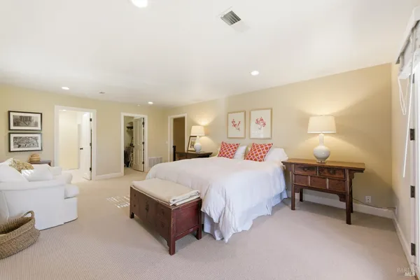 a spacious bedroom with a bed and a lamp
