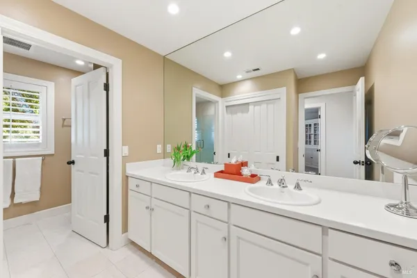 a bathroom with double sink and a mirror