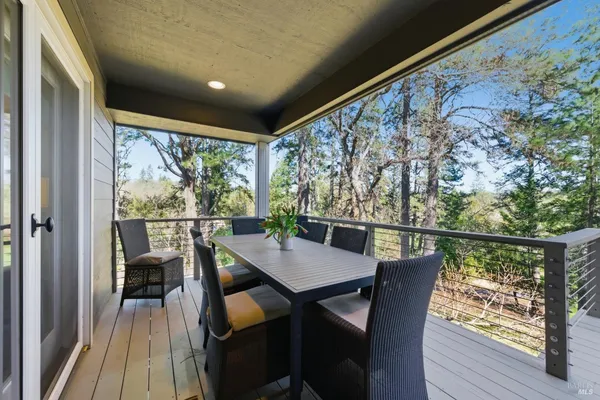 a view of a balcony with chairs and wooden floor