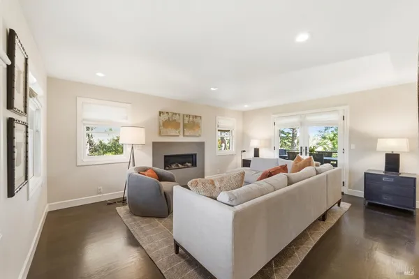 a living room with furniture a fireplace and a potted plant