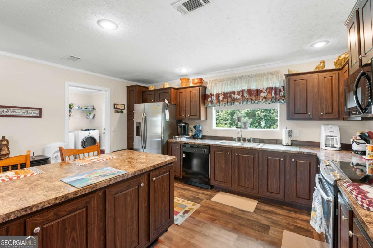 3516 Bennetts Landing Road Millen, GA 30442 - Photo 12 of 34 a kitchen with stainless steel appliances granite countertop a sink stove and refrigerator