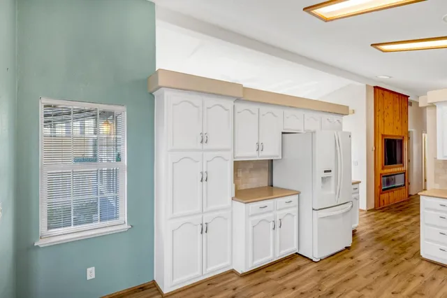 a view of a kitchen with wooden floor and electronic appliances