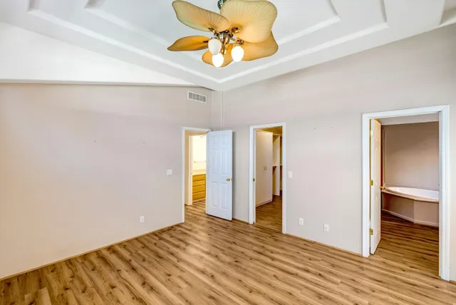 a view of room with wooden floor and ceiling fan