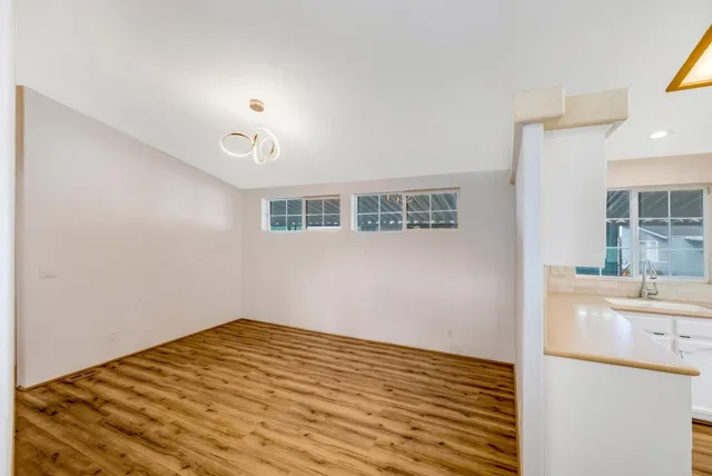 a view of a room with wooden floor and a ceiling fan