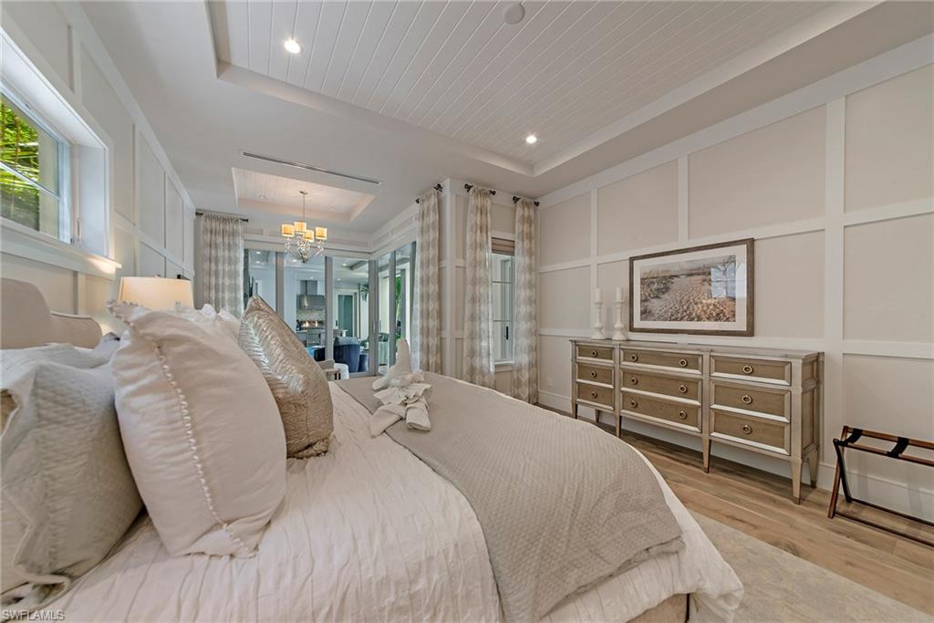 434 3rd Avenue South Naples, FL 34102 - Photo 18 of 24 a bedroom with a bed and a chandelier