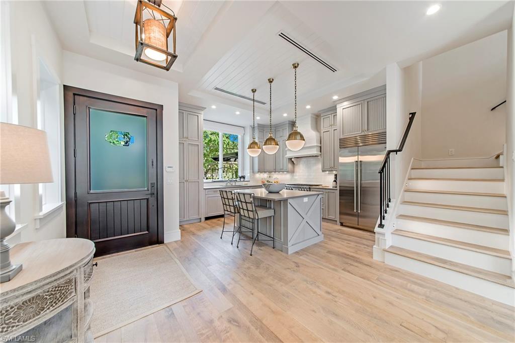 434 3rd Avenue South Naples, FL 34102 - Photo 2 of 24 a dining hall with couches a flat tv screen and a dining table with wooden floor