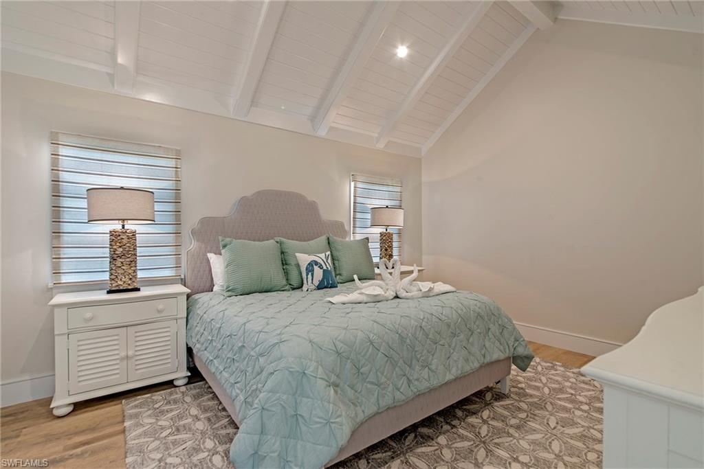 434 3rd Avenue South Naples, FL 34102 - Photo 9 of 24 a bedroom with a large bed and wooden floor