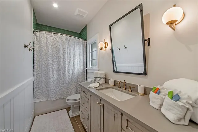 a bathroom with a granite countertop sink mirror and toilet