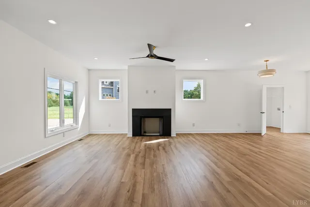 an empty room with windows and a fireplace