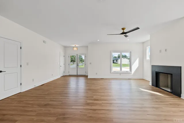 a view of an empty room with a window and fireplace