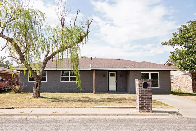 a front view of a house with a tree