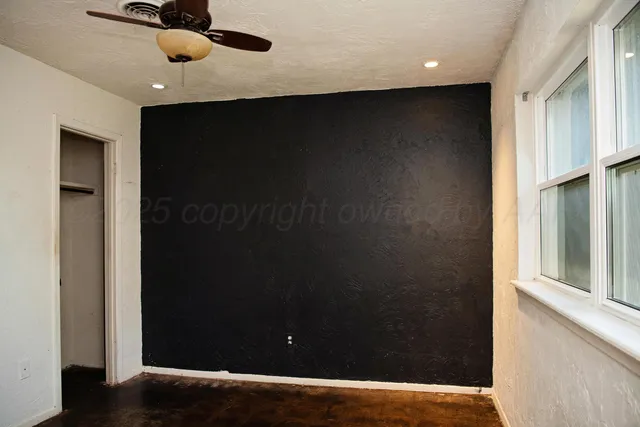 a backyard of a house with wooden fence and large trees