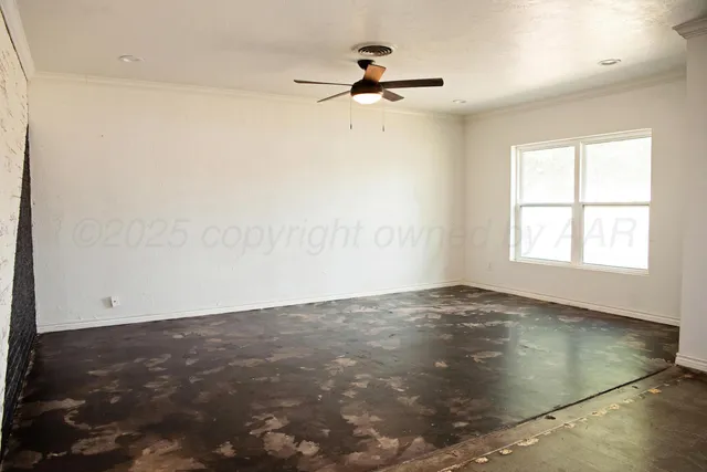 an empty room with a ceiling fan and window