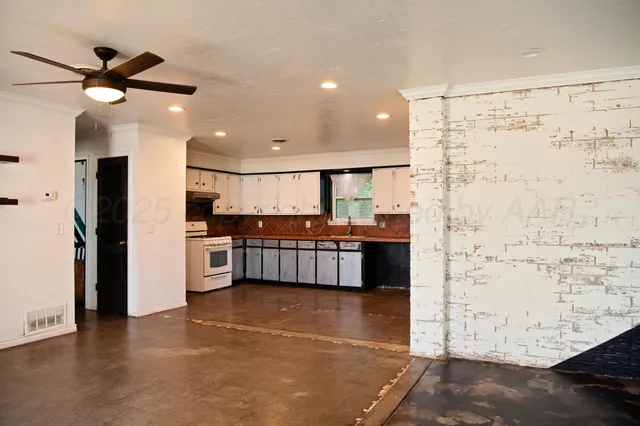 a kitchen with stainless steel appliances kitchen island granite countertop a refrigerator and a stove top oven