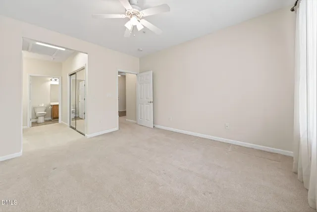 an empty room with a bathroom and a ceiling fan