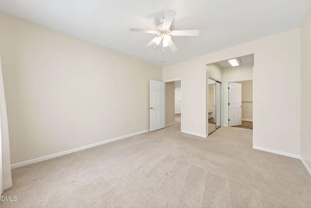 an empty room with a ceiling fan and a window