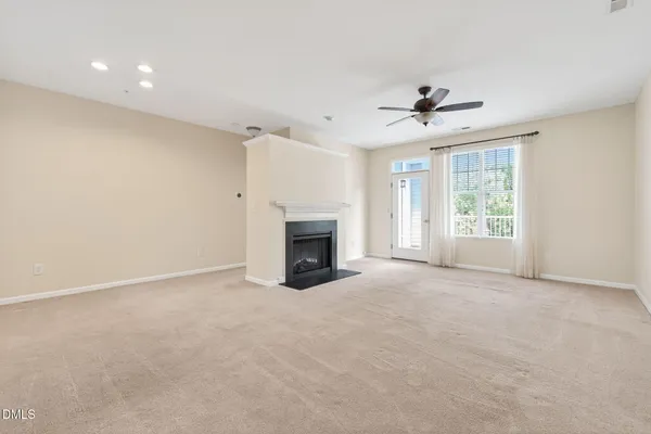 a view of a livingroom with a fireplace and a ceiling fan