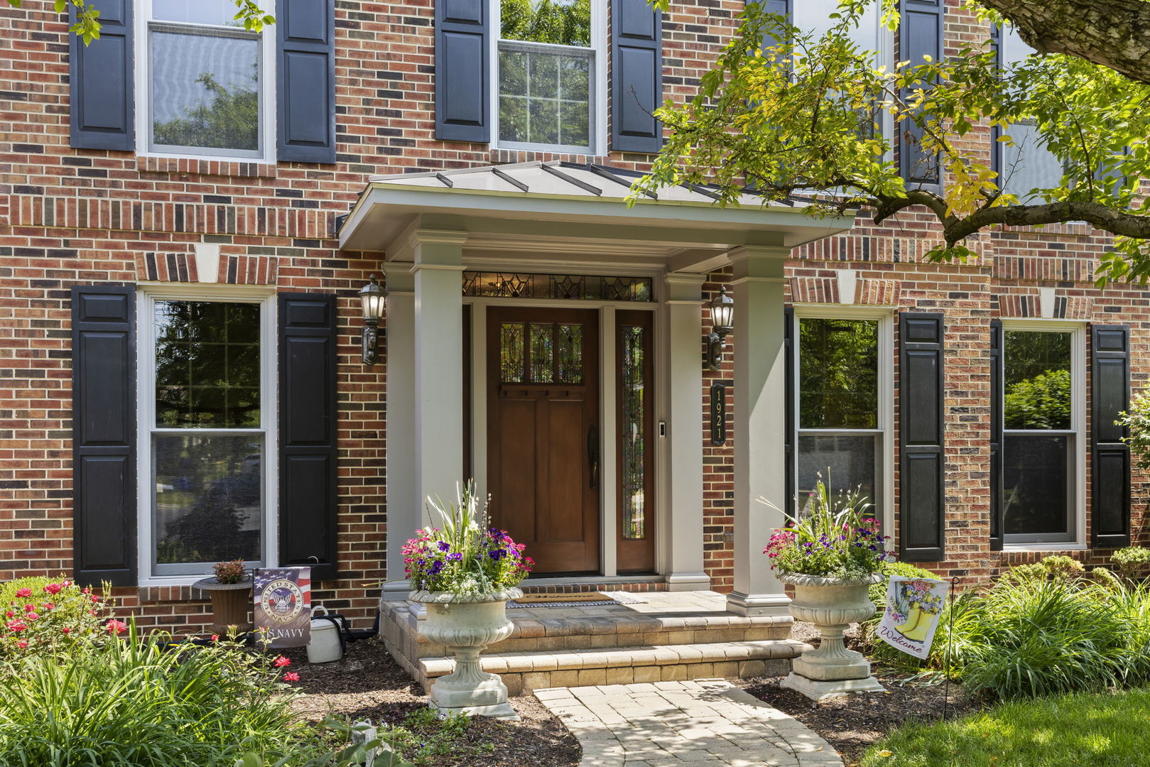 1921 Hampton Drive Wheaton, IL 60189 - Photo 3 of 54 front view of a brick house with a large window and potted plants