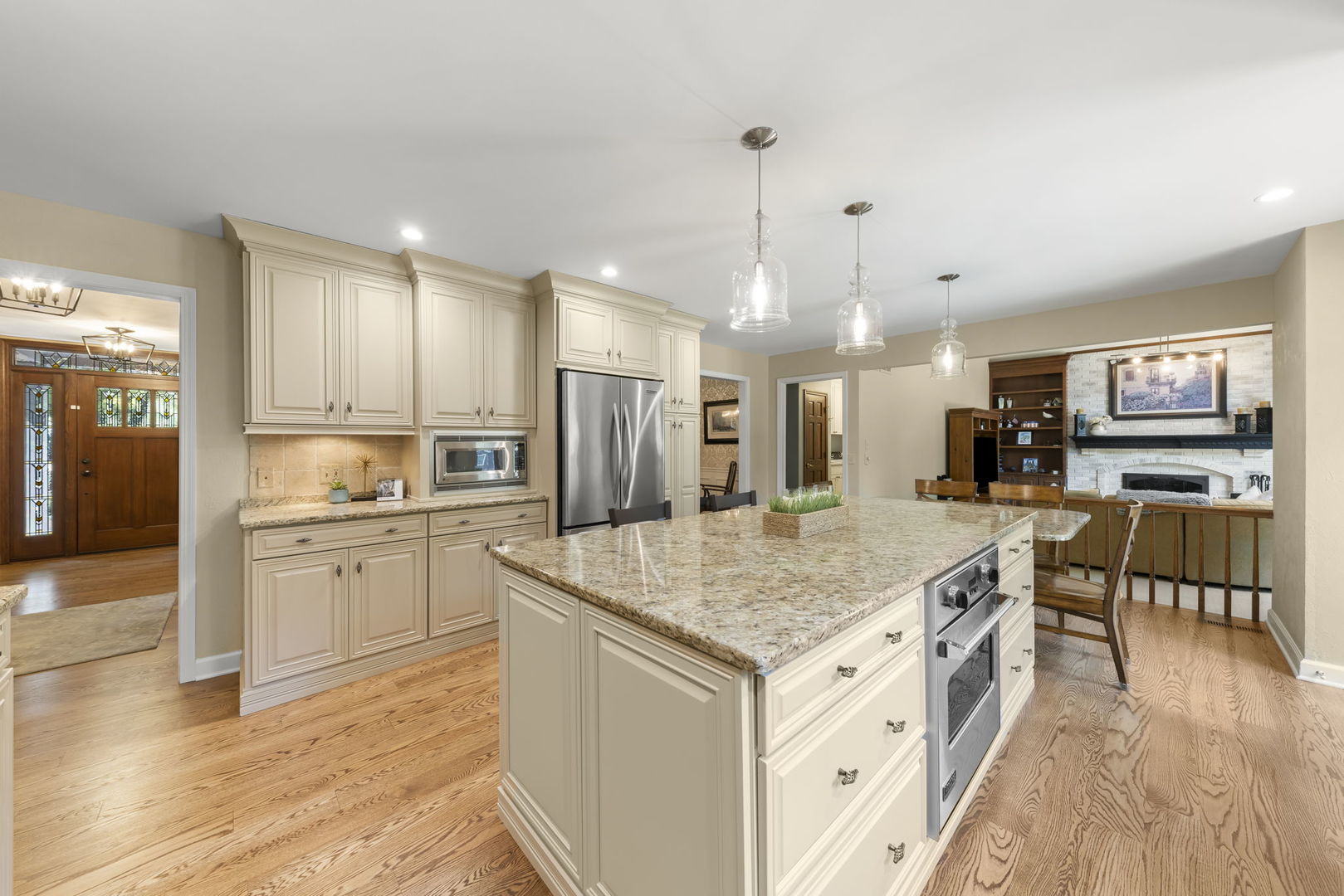 1921 Hampton Drive Wheaton, IL 60189 - Photo 6 of 54 a kitchen with stainless steel appliances granite countertop a kitchen island a stove a refrigerator a sink a dining table and chairs with wooden floor