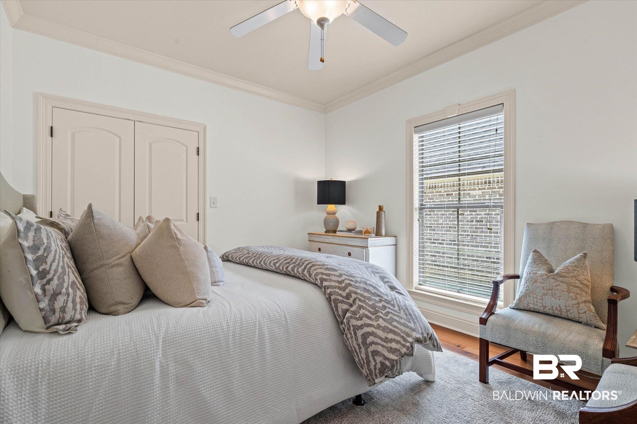 3459 Rue Royal Mobile, AL 36693 - Photo 19 of 31 Bright room featuring a window with blinds, wood-finish flooring, a ceiling fan, crown molding, and double arched panel doors