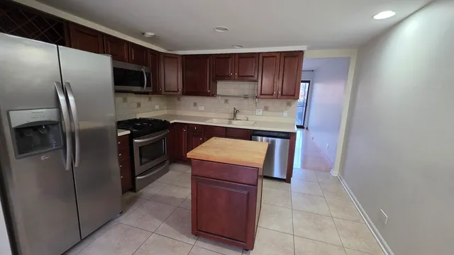 a kitchen with stainless steel appliances granite countertop a refrigerator stove and sink