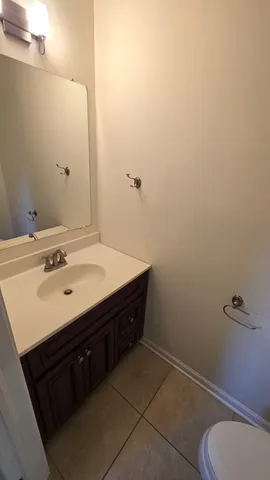 a bathroom with a sink toilet and a mirror