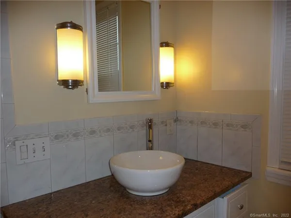 a bathroom with a granite countertop sink and a mirror