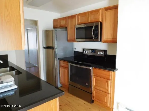 a kitchen with stainless steel appliances kitchen island granite countertop a stove and a microwave