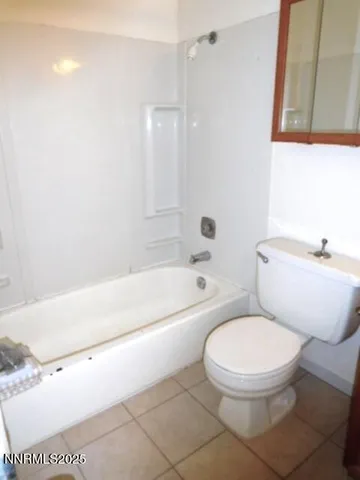 a white toilet sitting next to a bath tub