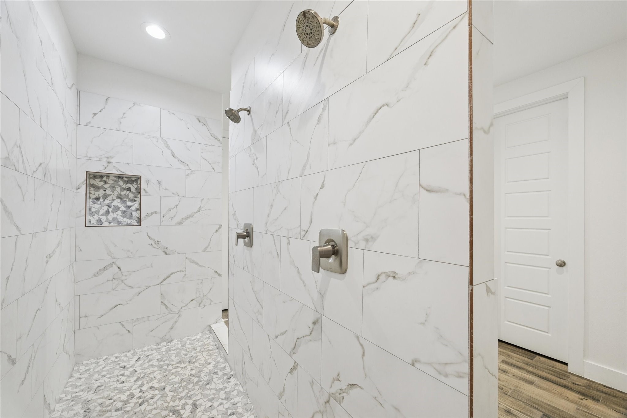 203 Hampton Glen Road Montgomery, TX 77356 - Photo 20 of 35 The ensuite shower offers a spacious and comfortable layout, featuring dual shower heads for added convenience. Subtle lighting enhances the space without compromising privacy, creating a bright, inviting, and luxurious shower experience.