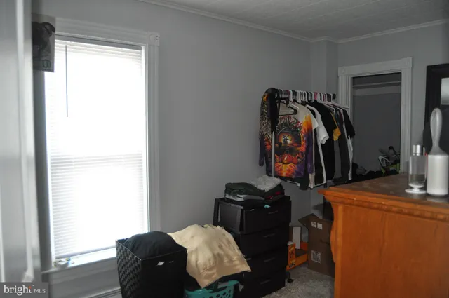 a walk in closet with clothes and shoes