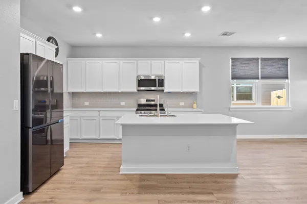 a kitchen with stainless steel appliances a stove a sink and a refrigerator