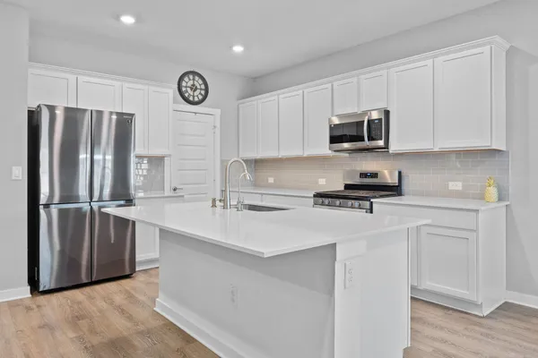 a kitchen with stainless steel appliances a refrigerator sink and cabinets